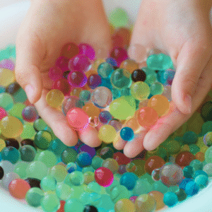 Colorful water beads held in hands, illustrating toys subject to U.S. CPSC water bead safety requirements